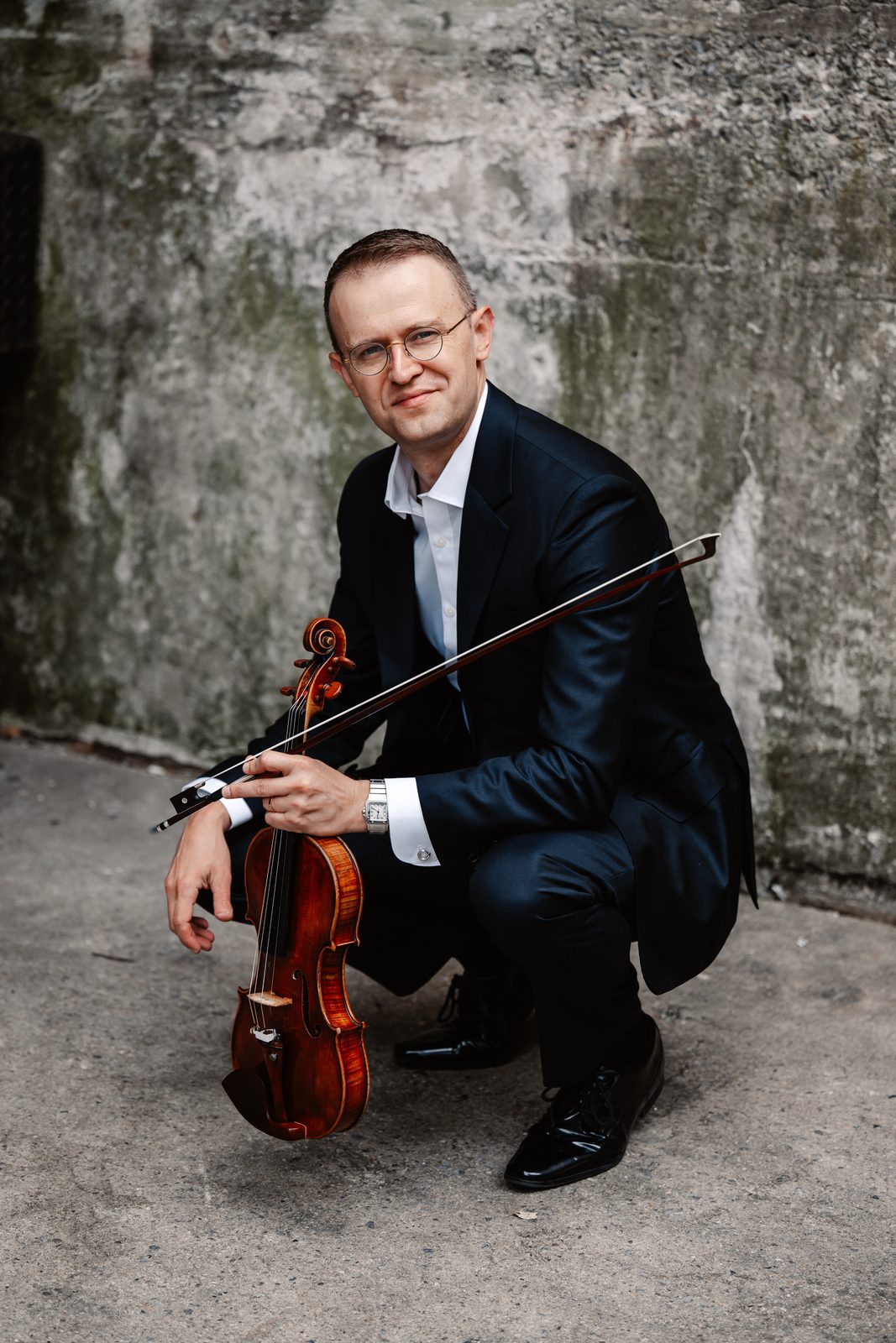 David Southorn holding his violin at his shoulder, warm brown background