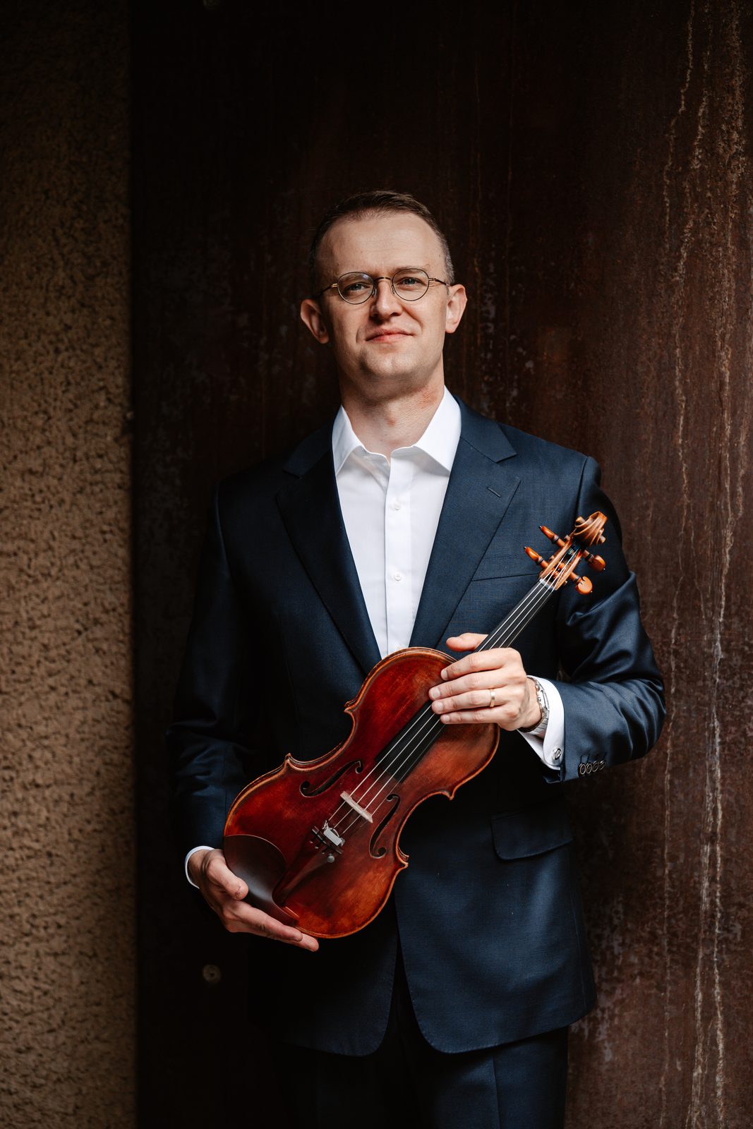 David Southorn, dark suit portrait with violin, dark blue background