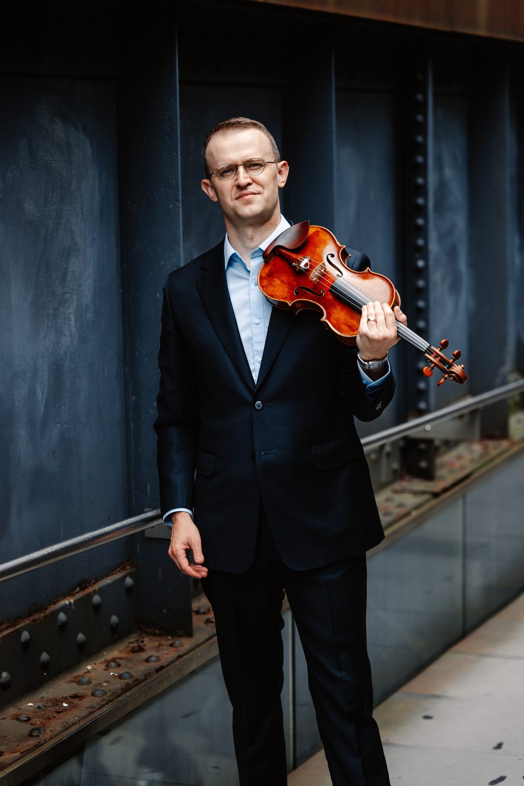 David Southorn, dark suit portrait with violin, dark brown background